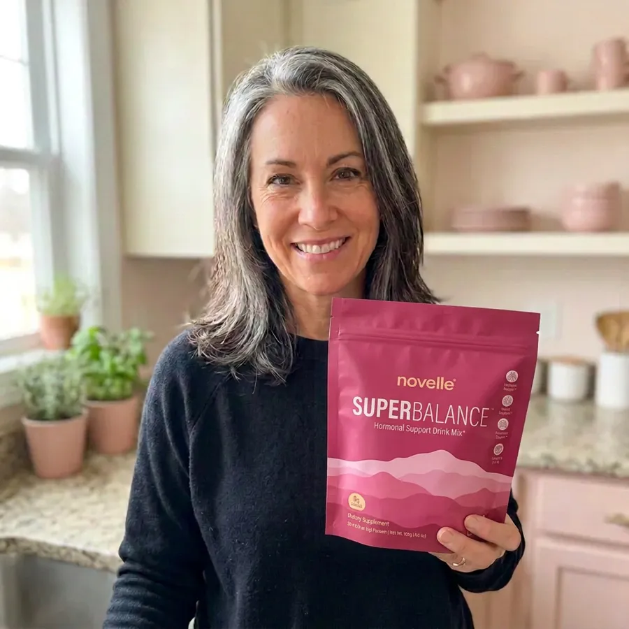 Michelle holding a pouch of SuperBalance in her kitchen