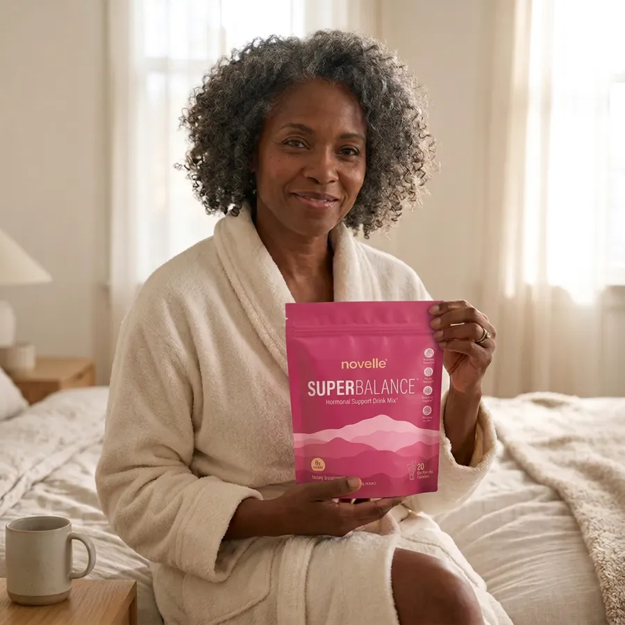 Grace holding a pouch of SuperBalance in her bedroom in morning light