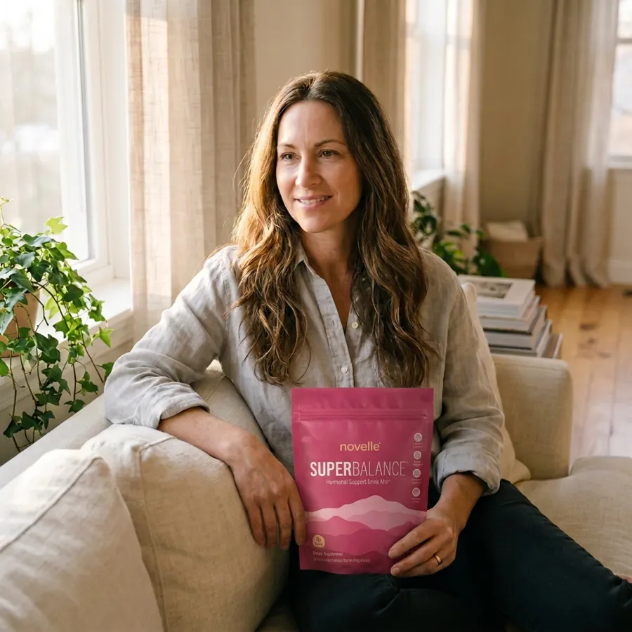 Bethany holding a pouch of SuperBalance on her sofa