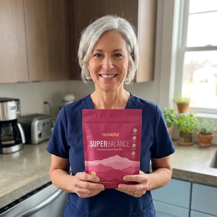Denise in her scrubs holding a pouch of SuperBalance before a shift